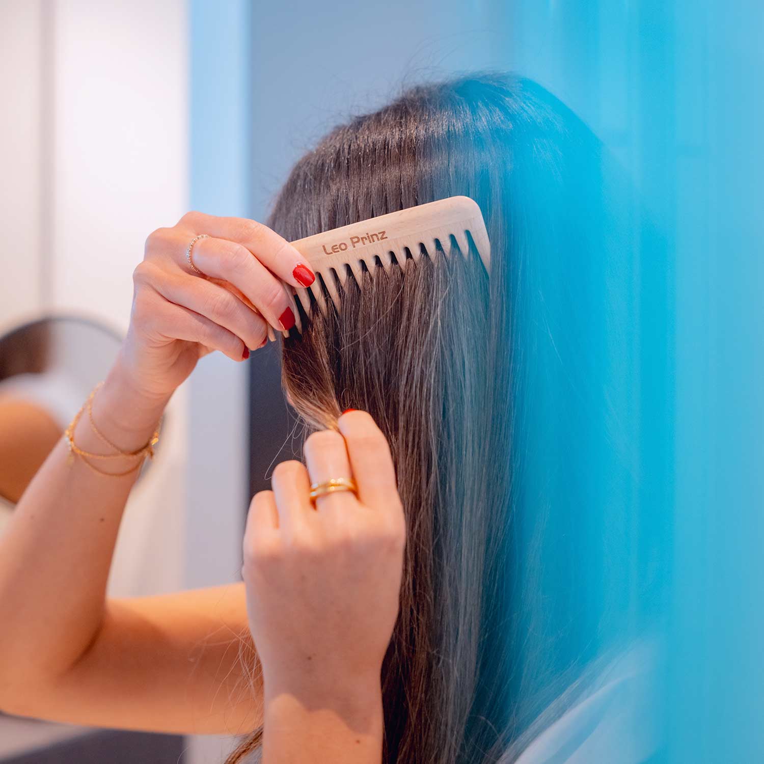 Woman using a detangling comb to gently style and untangle her hair, showcasing its ergonomic design.