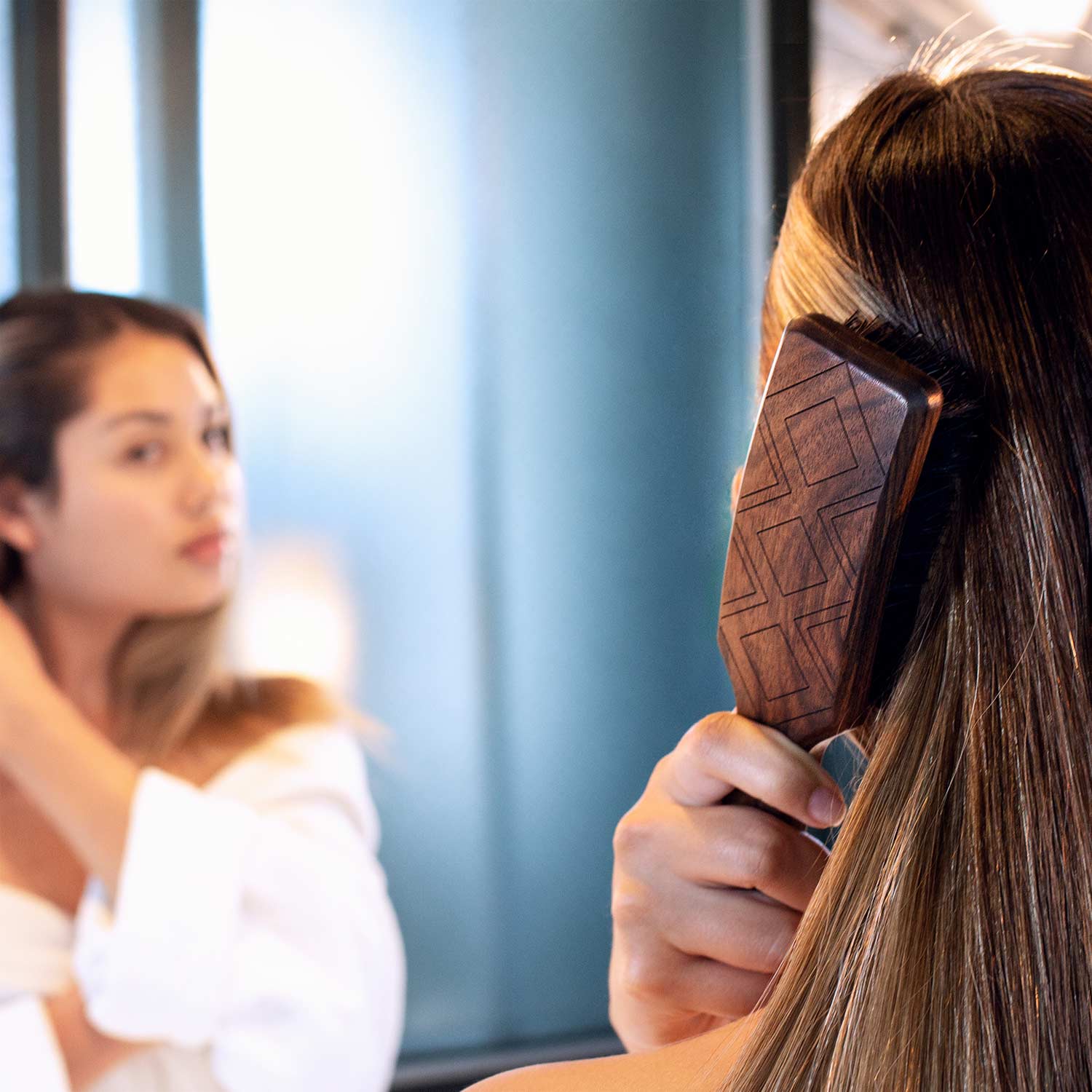 Frau mit schönen Haaren bürstet sich das Haar mit einer Naturborsten Bürste von Leo Prinz